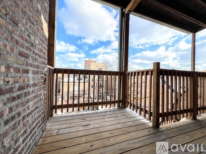 A wooden deck with a brick wall and a view of the sky.