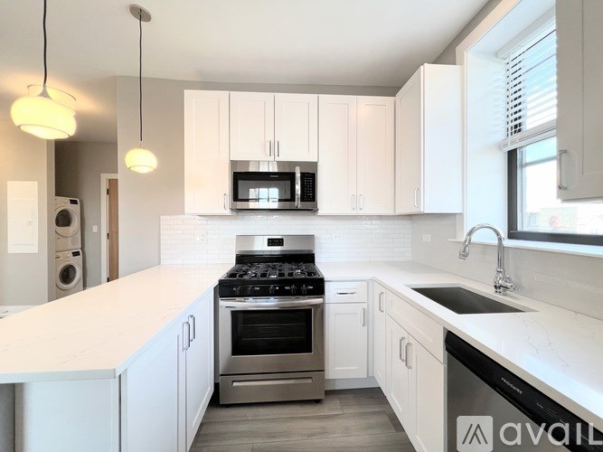 A modern kitchen with white cabinets and stainless steel appliances.