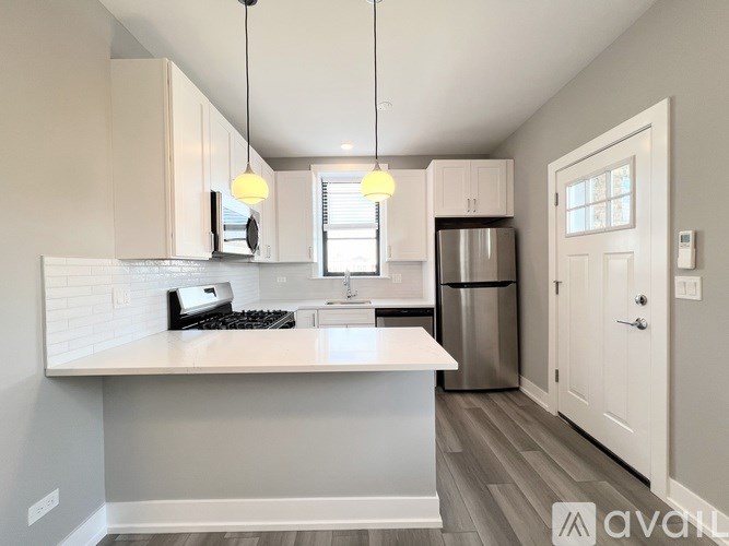 A kitchen with a white countertop and a stainless steel refrigerator.