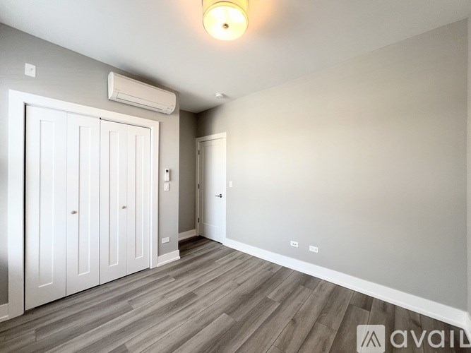 A room with a wooden floor and a white door.