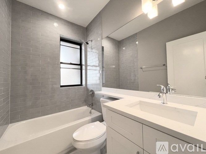 A bathroom with a white tub, sink, and toilet.