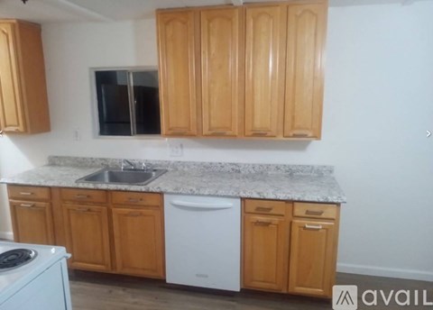A kitchen with wooden cabinets and a granite countertop.