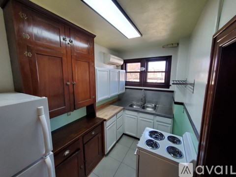 A kitchen with wooden cabinets and a white refrigerator.