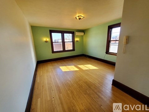 A room with wooden floors and two windows.