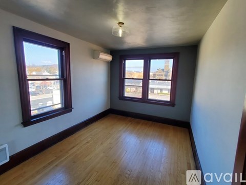 A room with wooden floors and two windows.