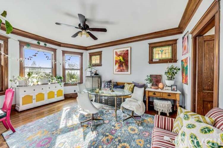 A sunny day outside the window in a room with a ceiling fan.