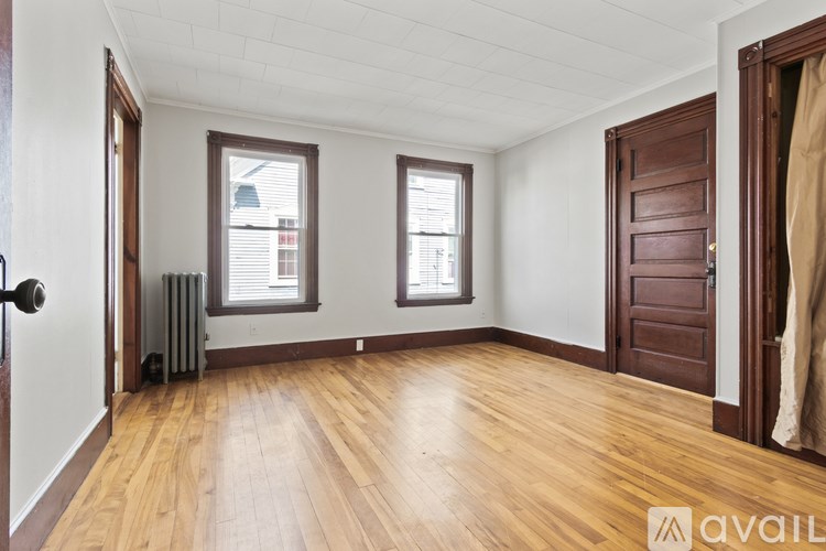 A room with wooden floors and two windows.