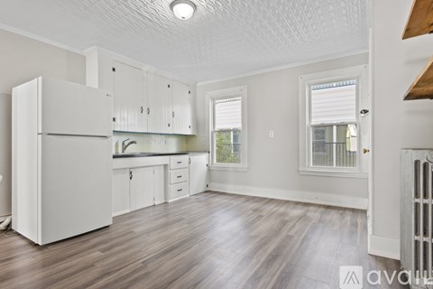 A kitchen with white cabinets and a white refrigerator.