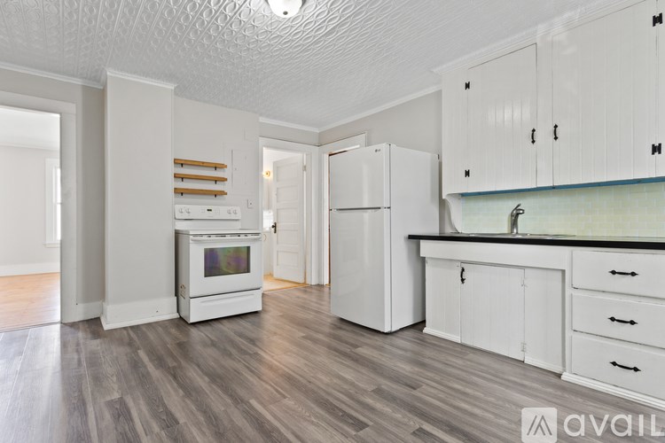 A kitchen with white appliances and cabinets.