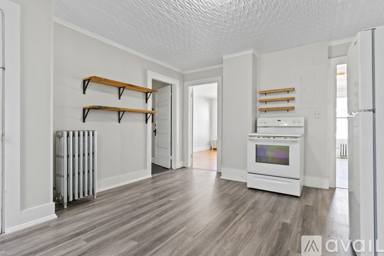 A spacious kitchen with white appliances and wood flooring.