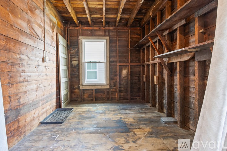 A room under construction with wooden walls and a window.