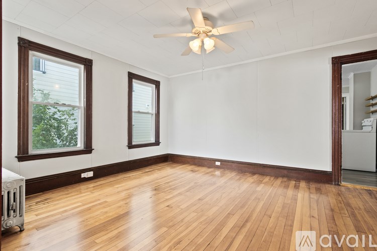 A room with wooden floors and a ceiling fan.