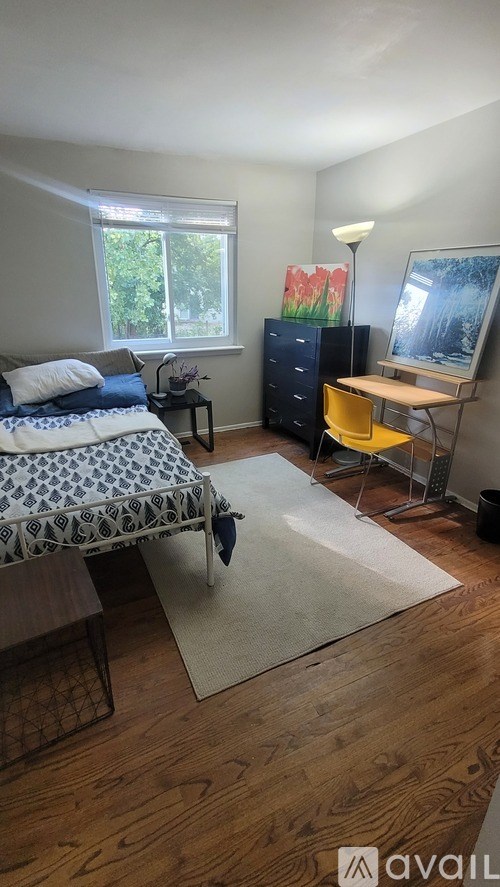 A bedroom with a bed, a chair, a cabinet, and a painting on the wall.