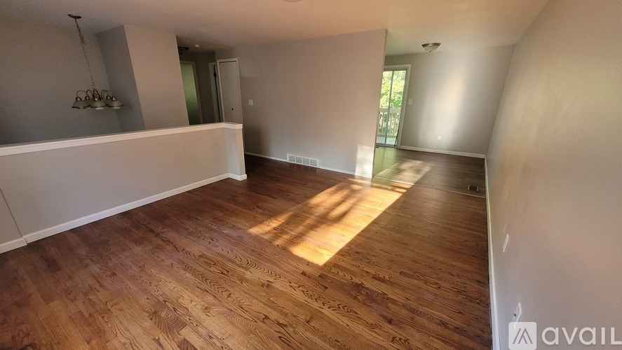 A room with wooden flooring and white walls is available for rent.