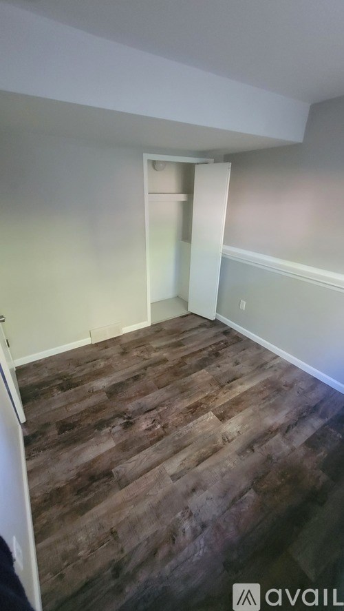 A room with wooden flooring and a white door.
