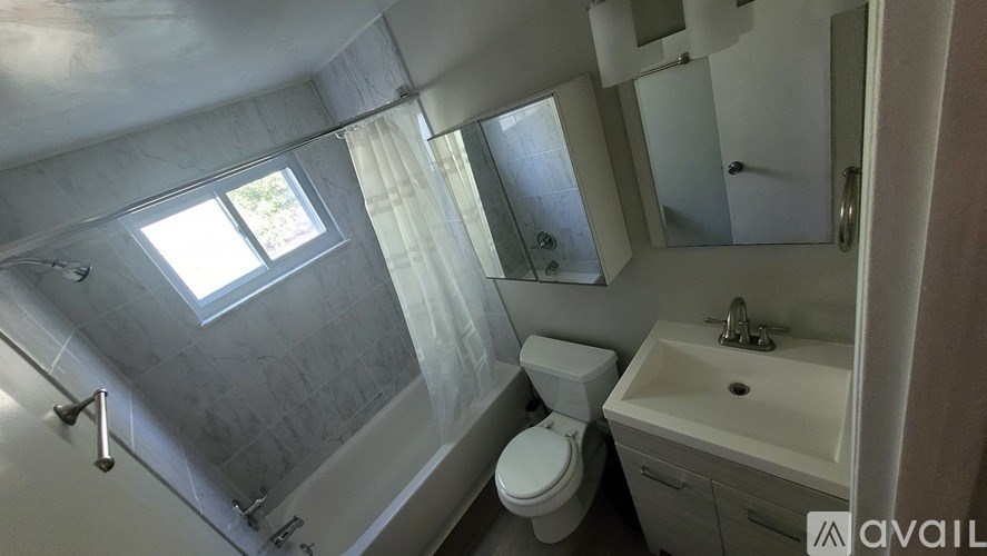 A bathroom with a toilet, sink, and shower.