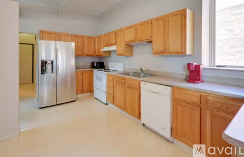 A kitchen with wooden cabinets and a refrigerator.