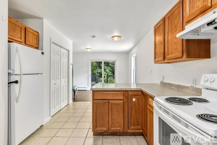 A kitchen with white appliances and wooden cabinets.