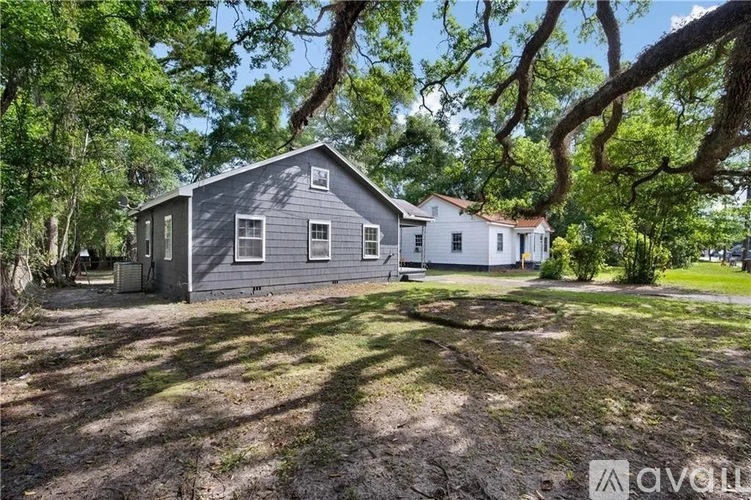 A house with a grey roof is surrounded by trees.