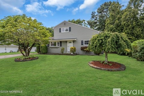 A house with a well-maintained lawn and a tree in the front yard.