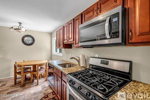 A kitchen with a stove, microwave, and oven.
