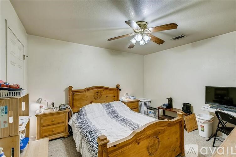 A bedroom with a bed, nightstand, and a ceiling fan.