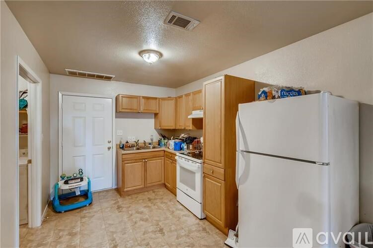 A kitchen with white appliances and wooden cabinets.