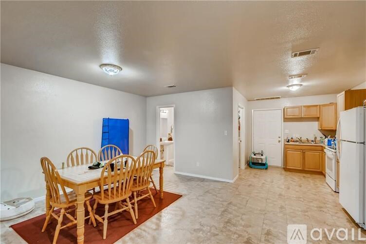 A kitchen with a dining table and chairs in the foreground.