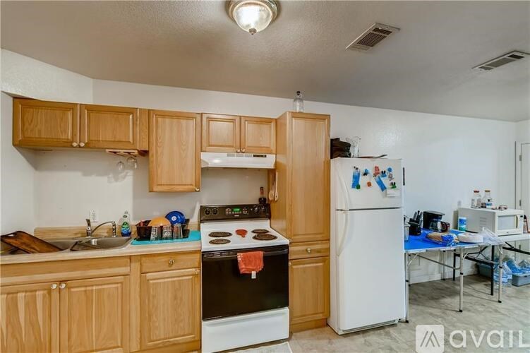A kitchen with wooden cabinets and a white refrigerator.