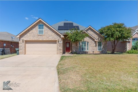 A house with a garage and a driveway in front.