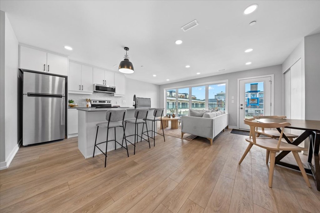 A modern kitchen with wooden floors and a large island.