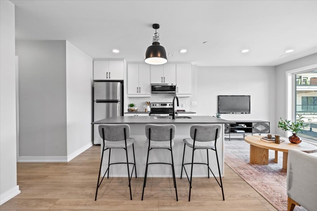 A modern kitchen with a refrigerator, stove, and sink.
