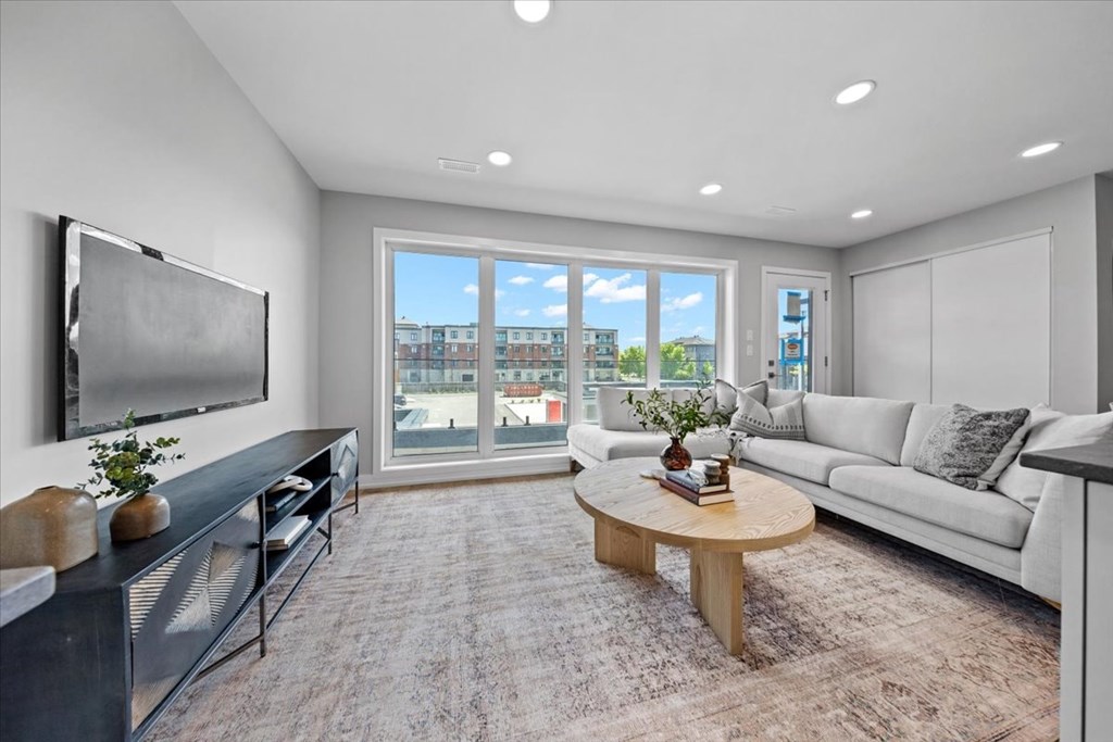 A modern living room with a flat screen TV mounted on the wall.