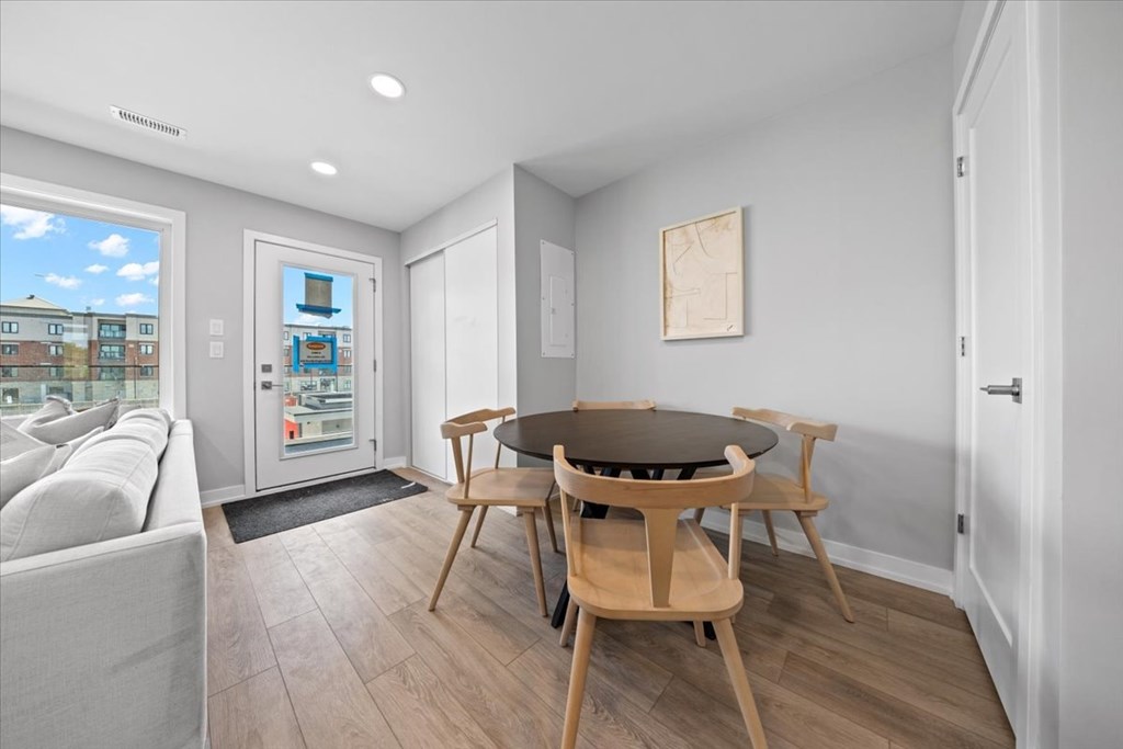 A dining room with a table and chairs.
