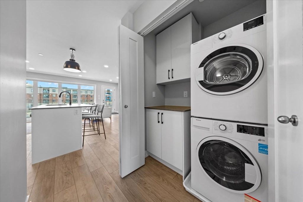 A modern laundry room with a washer and dryer built into the cabinetry.