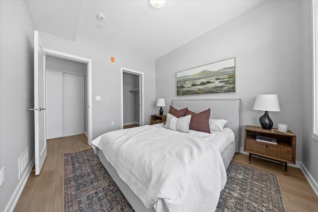 A bedroom with a large bed and a painting on the wall.