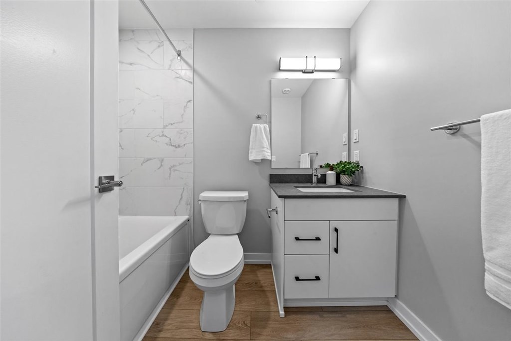A white bathroom with a toilet, sink, and bathtub.