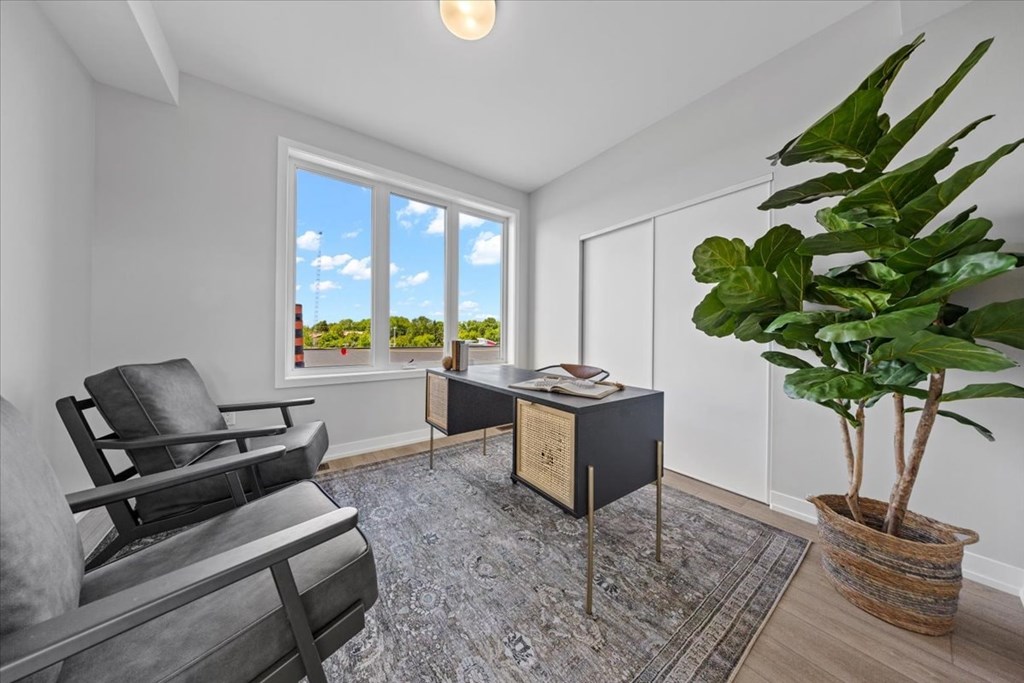 A room with a chair, a table, and a potted plant.