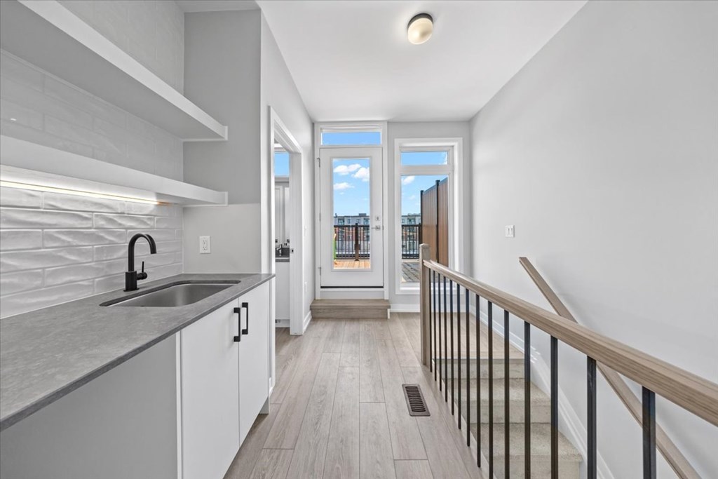 A modern kitchen with a sink, cabinets, and a window.