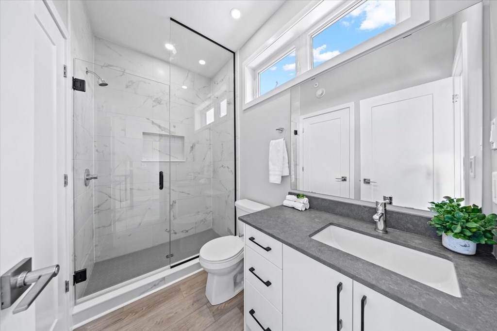 A modern bathroom with a walk-in shower and a toilet.
