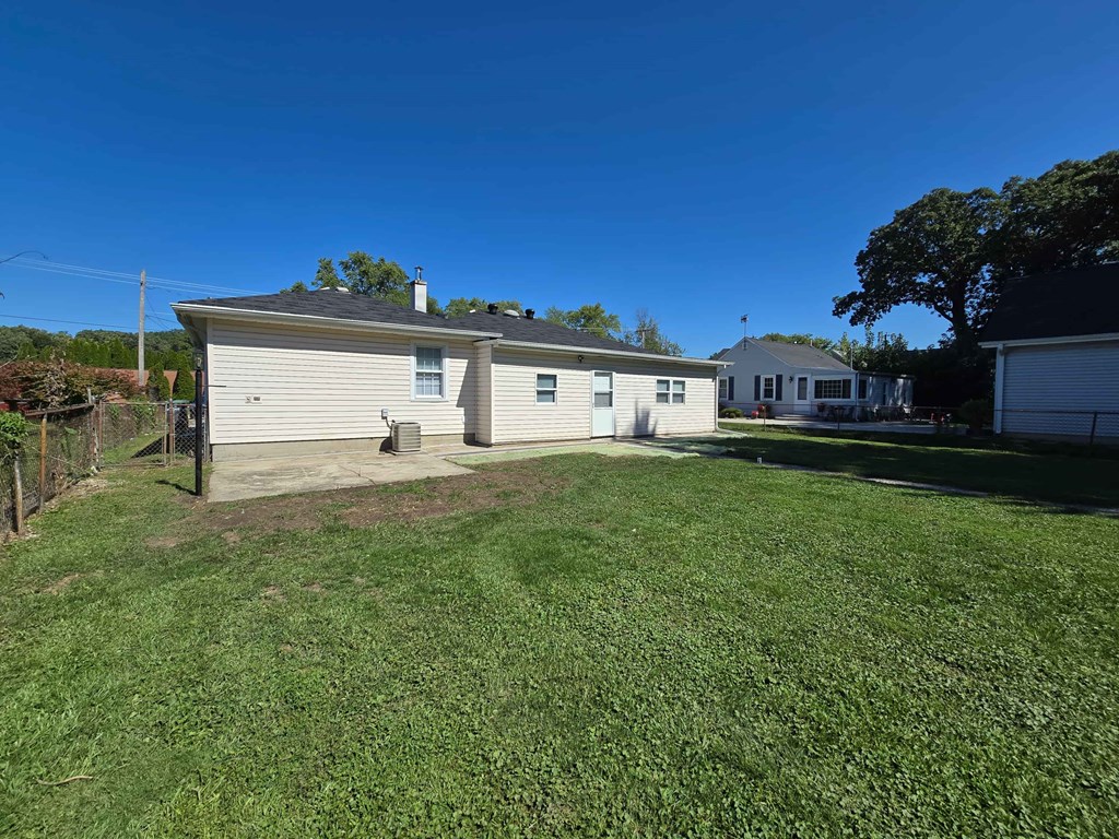 A house with a garage and a driveway is surrounded by a grassy yard.