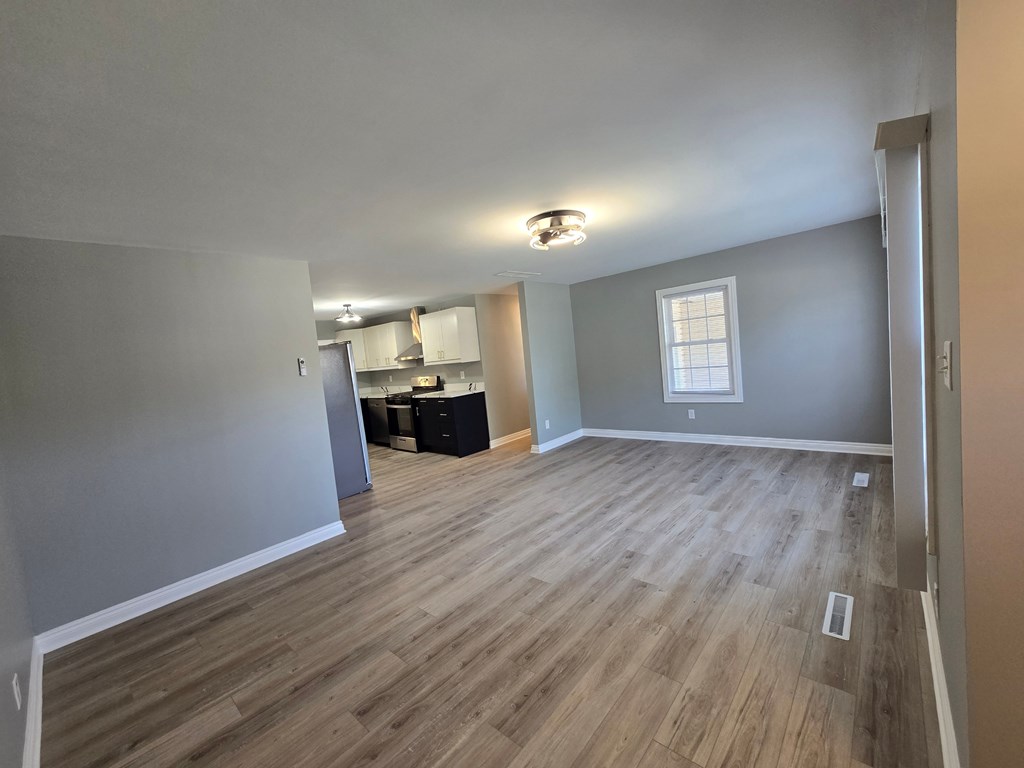 A room with wooden flooring and a window.