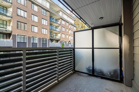 A view of a balcony with a metal railing and a glass door.