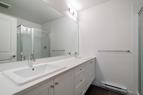 A white bathroom with a sink and mirror.