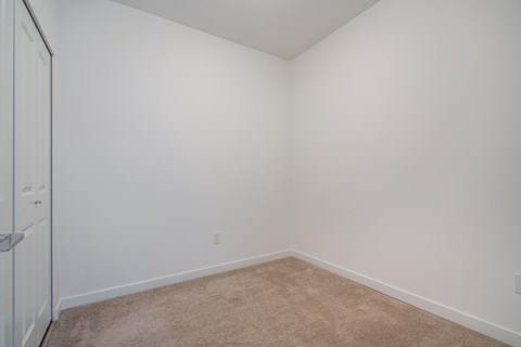 A room with white walls and carpeted floor.