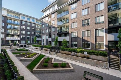 A modern apartment complex with a courtyard and landscaping.