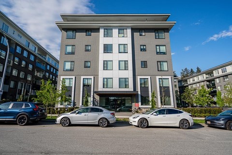A modern building with cars parked in front.
