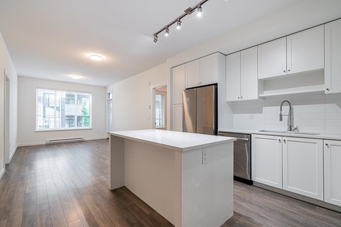 A kitchen with white cabinets and a wooden island.