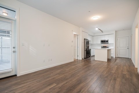 A large empty room with wooden floors and white walls.