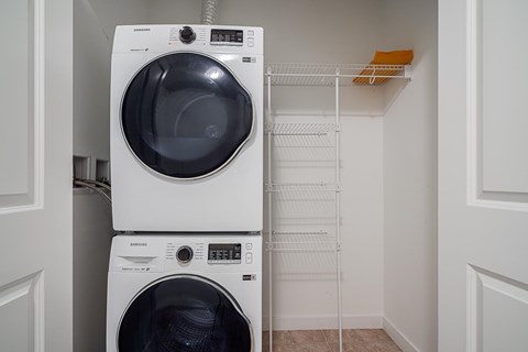Two white front loading washing machines in a small laundry room.